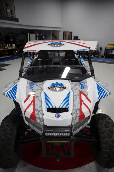 A Arctic Cat Wildcat XX side-by-side with a red, white, and blue American hero Fractal custom vinyl wrap.