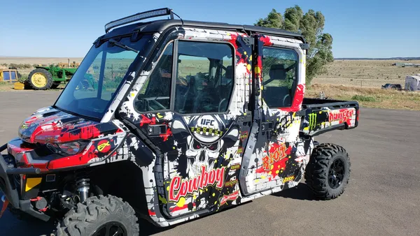 A Can-Am Defender Max side-by-side with a red, white, and black grunge skull Cowboy Cerrone UFC custom vinyl wrap.