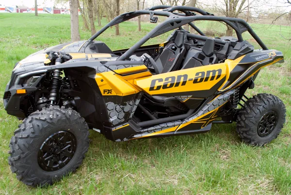 A Can-Am Maverick X3 side-by-side with a yellow, black, and dark gray honeycomb Paradigm custom vinyl wrap.