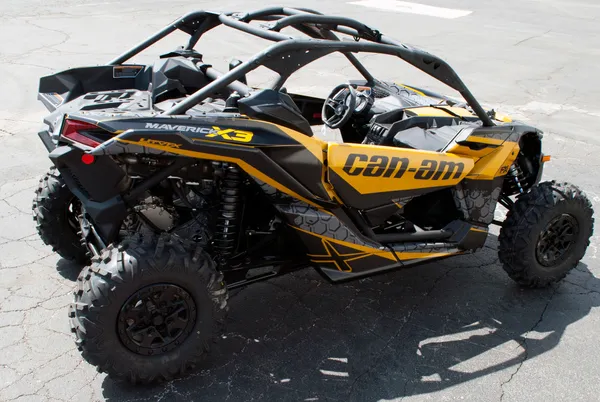 A Can-Am Maverick X3 side-by-side with a yellow, black, and dark gray honeycomb Paradigm custom vinyl wrap.