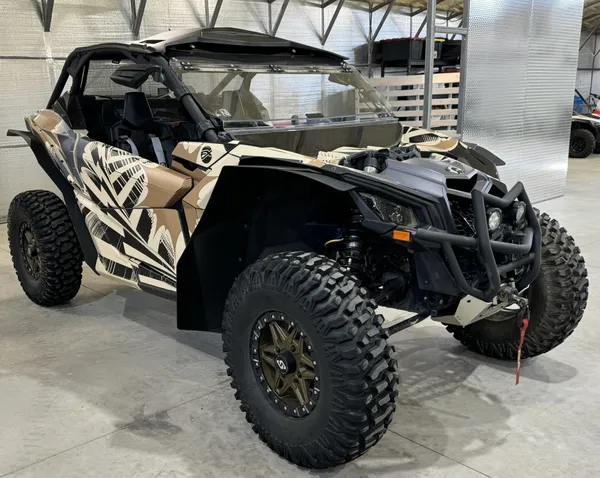A Can-Am Maverick X3 side-by-side with a stricken custom vinyl wrap