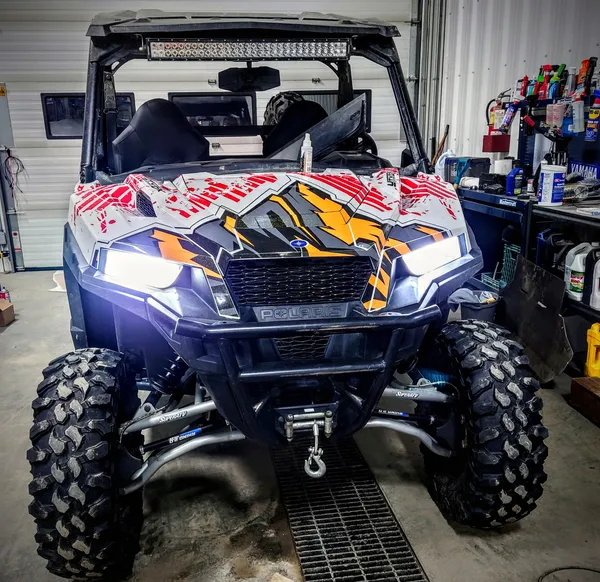 A Polaris General 2 Door side-by-side with a white, red, grey and orange Altitude vinyl wrap.