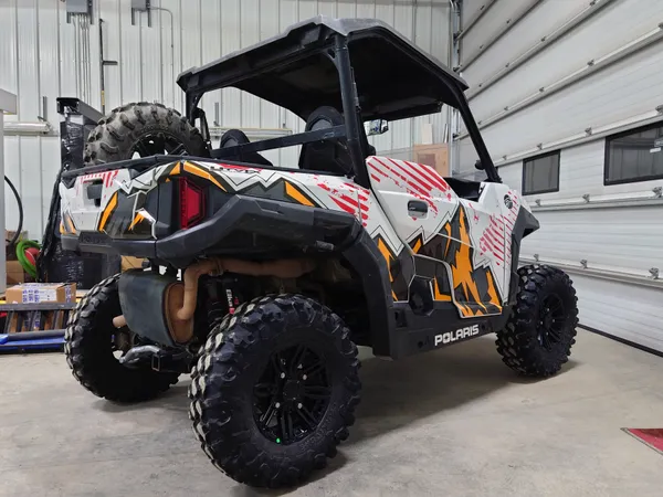 A Polaris General 2 Door side-by-side with a white, red, grey and orange Altitude vinyl wrap.