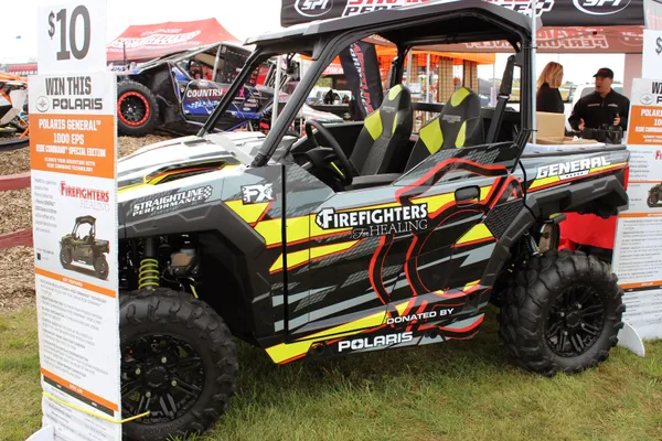 A Polaris General 2 Door side-by-side with a red, gray and black firefighter custom vinyl wrap.
