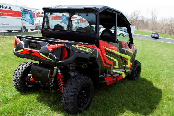 A Polaris General 4 Door side-by-side with a black, red and lime Rogue custom vinyl wrap.