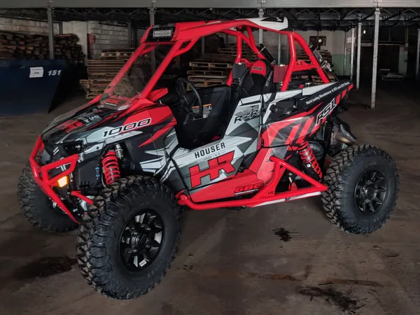 A Polaris RS1 side-by-side with a black and red Houser Racing custom vinyl wrap.