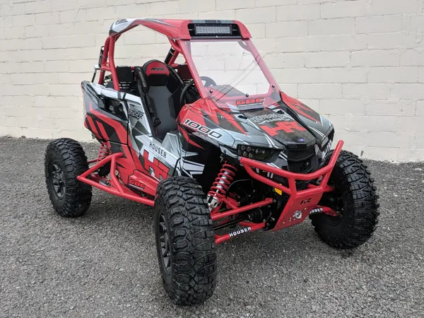 A Polaris RS1 side-by-side with a black and red Houser Racing custom vinyl wrap.