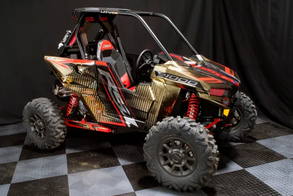 A Polaris RS1 side-by-side with a red, black, and gold halftone stripes custom vinyl wrap.