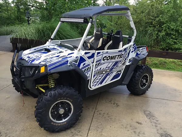 A Polaris RZR 2 Door side-by-side with a blue and white Evasion custom vinyl wrap.