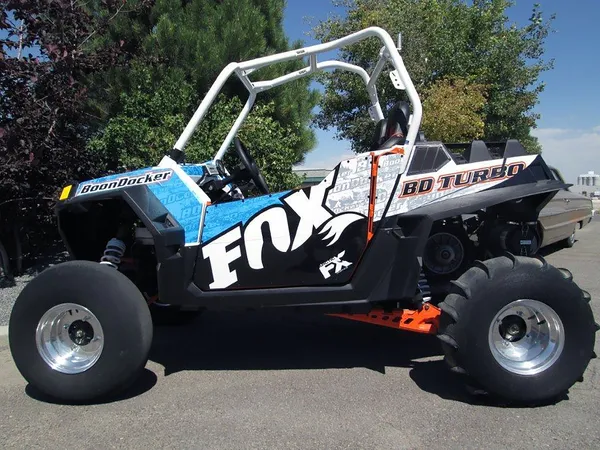 A Polaris RZR 2 Door side-by-side with a black and white Fox custom vinyl wrap.
