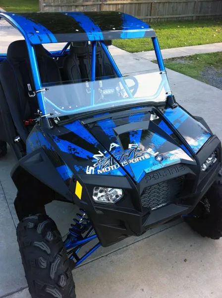 A Polaris RZR 2 Door side-by-side with a blue and black Rising Sun custom vinyl wrap.