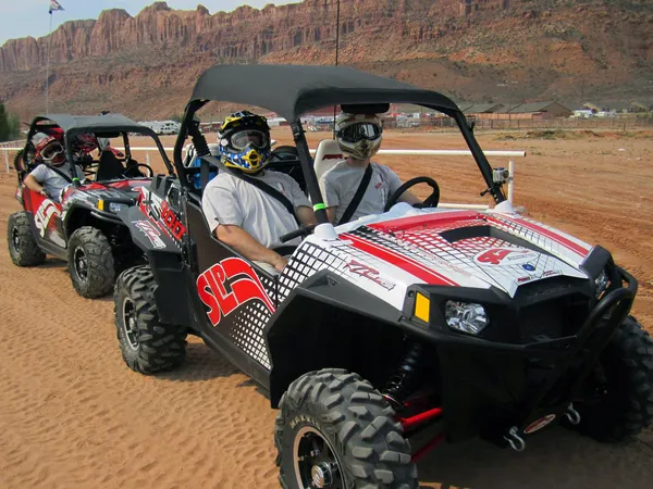 A Polaris RZR 2 Door side-by-side with a red and white SLP custom vinyl wrap.