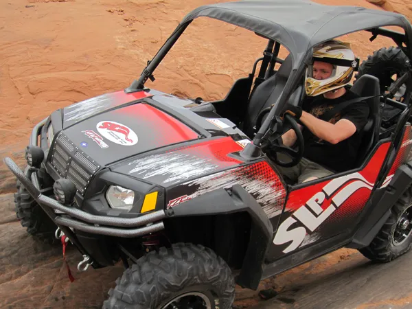 A Polaris RZR 2 Door side-by-side with a red and black SLP custom vinyl wrap.