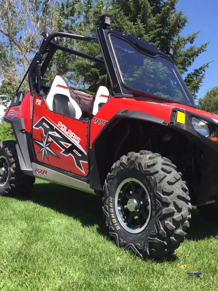 A Polaris RZR 2 Door side-by-side with a red and white stock match custom vinyl wrap.