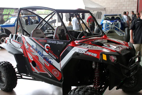 A Polaris RZR 2 Door side-by-side with a red, black and white custom vinyl wrap.