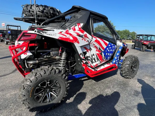 A Polaris RZR PRO XP 2 Door side-by-side with a red, white, and blue grunge American Flag custom vinyl wrap.