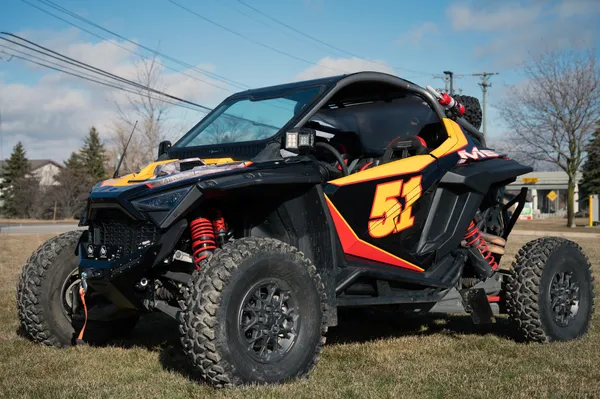 A Polaris RZR PRO XP 2 Door side-by-side with a red, black, and yellow movie replica Ricky Bobby custom vinyl wrap.