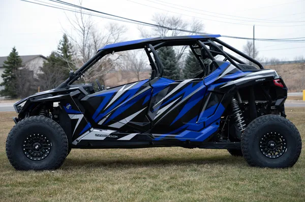 A Polaris RZR PRO XP 4 Door side-by-side with a blue and black stripes Evolution custom vinyl wrap.
