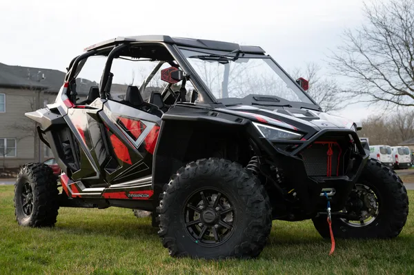 A Polaris RZR PRO XP 4 Door side-by-side with a red, black, and gray grunge Rogue custom vinyl wrap.