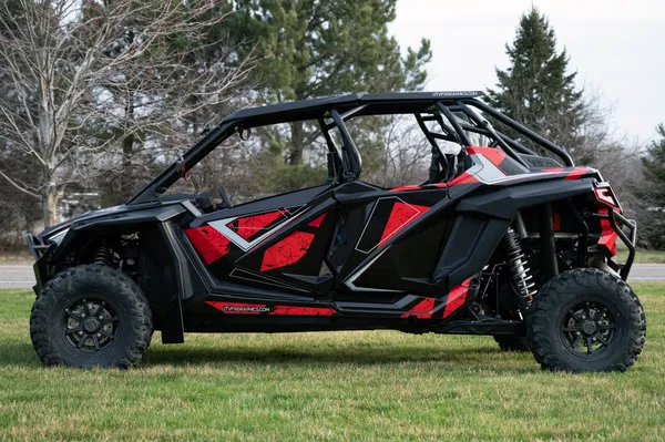 A Polaris RZR PRO XP 4 Door side-by-side with a red, black, and gray grunge Rogue custom vinyl wrap.