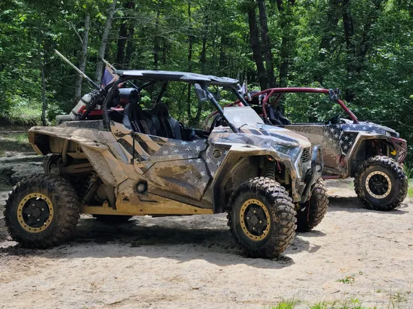 A Polaris RZR XP 2 Door 2018+ side-by-side with a gray, tan, and black grunge American Flag custom vinyl wrap.