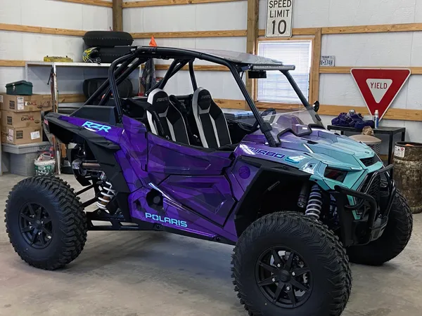 A Polaris RZR XP 2 Door 2018+ side-by-side with a purple, aqua, and blue abstract geometric gradient  custom vinyl wrap.