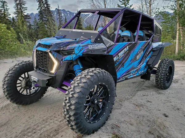 A Polaris RZR XP 4 Door 2018+ side-by-side with a blue, purple, and black grunge Blackout custom vinyl wrap.