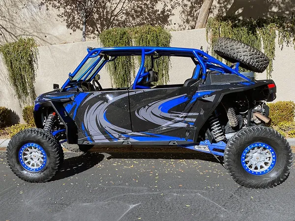 A Polaris RZR XP 4 Door 2018+ side-by-side with a black, gray, and blue grunge swirl Surge custom vinyl wrap.