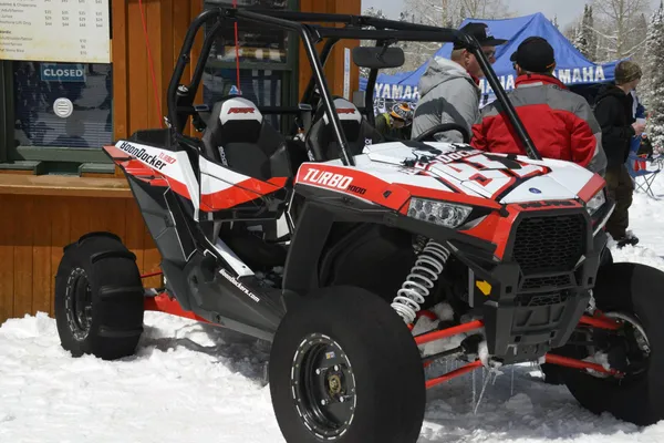 A Polaris RZR XP 2 Door side-by-side with a red, black, and white stripes Boondocker Turbo custom vinyl wrap.