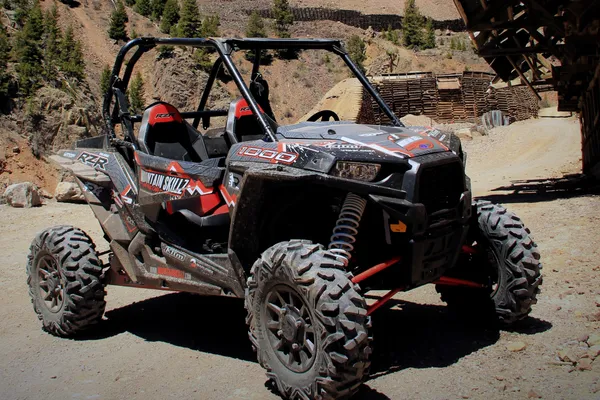 A Polaris RZR XP 2 Door side-by-side with a white, red, and black grunge mountain Entz Frontier custom vinyl wrap.