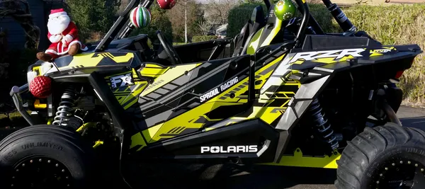 A Polaris RZR XP 2 Door side-by-side with a lime squeeze, gray, and black stripes Evasion custom vinyl wrap.