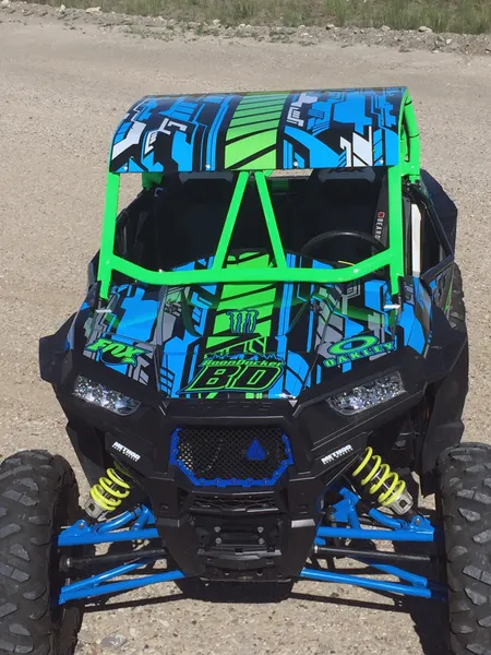 A Polaris RZR XP 2 Door side-by-side with a blue, lime, and black stripes Evasion custom vinyl wrap. 