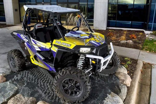 A Polaris RZR XP 2 Door side-by-side with a yellow, purple, and black Minnesota Vikings custom vinyl wrap.