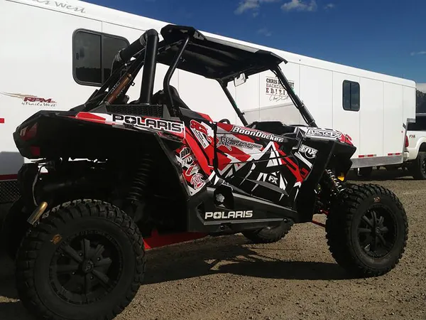A Polaris RZR XP 2 Door side-by-side with a red, white, and black mountain custom vinyl wrap.