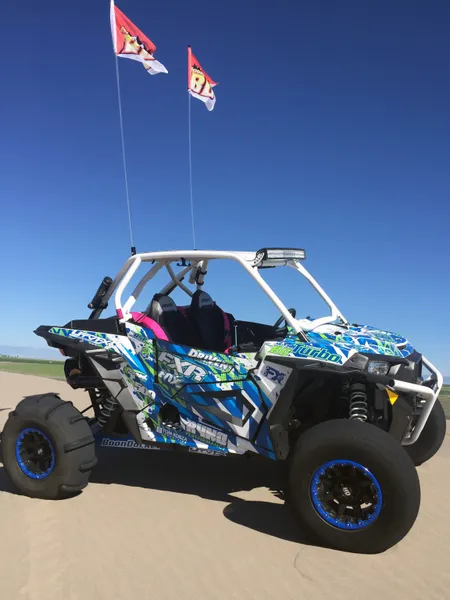 A Polaris RZR XP 2 Door side-by-side with a blue, green, and white lightning design Voltage custom vinyl wrap.