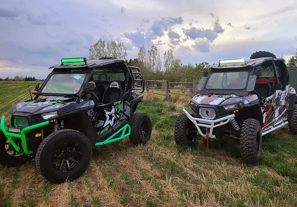 A Polaris RZR XP 2 Door side-by-side with a lime, white, and black grunge Wartorn custom vinyl wrap.