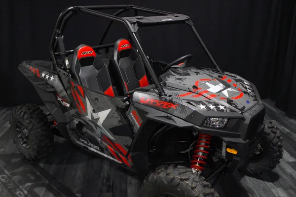 A Polaris RZR XP 2 Door side-by-side with a gray, red, and black grunge Wartorn custom vinyl wrap.