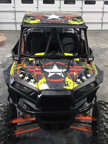 A Polaris RZR XP 2 Door side-by-side with a lime squeeze, red, and black grunge Wartorn custom vinyl wrap.