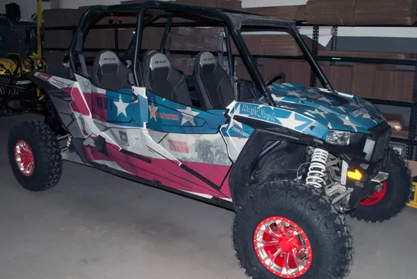 A Polaris RZR XP 4 Door side-by-side with a red, white, and blue American Fallen Heroes custom vinyl wrap.