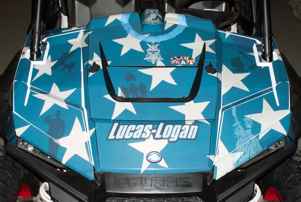 A Polaris RZR XP 4 Door side-by-side with a red, white, and blue American Fallen Heroes custom vinyl wrap.