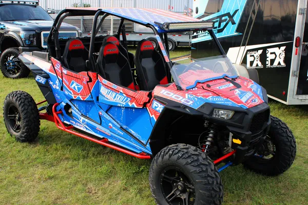 A Polaris RZR XP 4 Door side-by-side with a white, red, and blue grunge mountain Entz Frontier custom vinyl wrap.