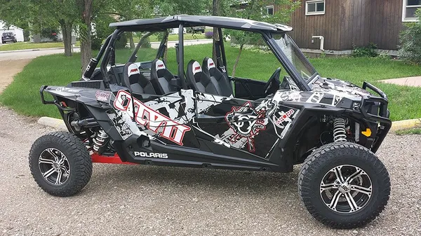 A Polaris RZR XP 4 Door side-by-side with a black, gray, and red grunge 307 Rising Sun custom vinyl wrap.