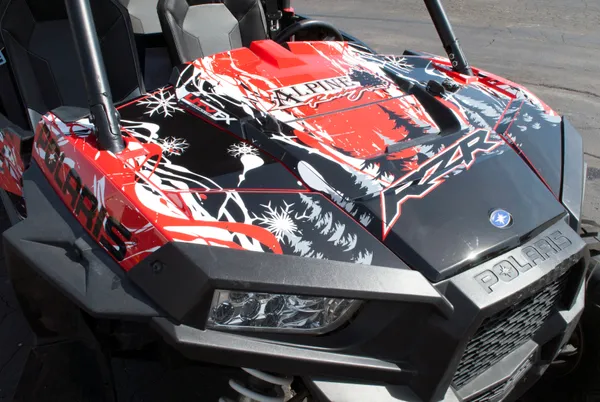 A Polaris RZR XP 4 Door side-by-side with a red, white, and black grunge Sub Zero custom vinyl wrap.