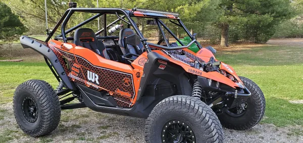 A Yamaha YXZ1000R side-by-side with a orange, black, and white striped honeycomb custom vinyl wrap.