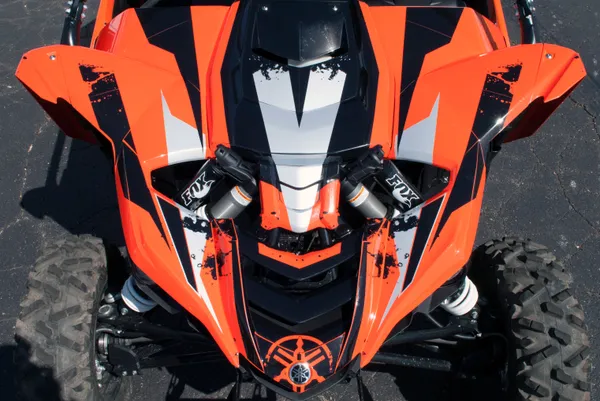 A Yamaha YXZ1000R side-by-side with a orange, black, and gray grunge stripe Race custom vinyl wrap.