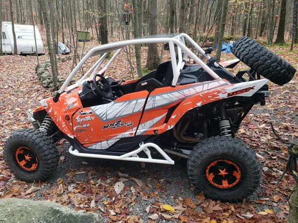 A Yamaha YXZ1000R side-by-side with a orange, gray, and white geometric pattern Virus custom vinyl wrap.