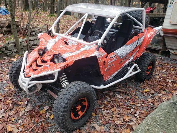 A Yamaha YXZ1000R side-by-side with a orange, gray, and white geometric pattern Virus custom vinyl wrap.