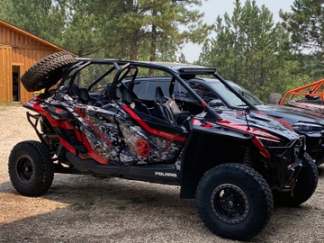 A Polaris RZR PRO XP 4 Door side-by-side with a red, black, and white digital camo custom custom vinyl wrap.